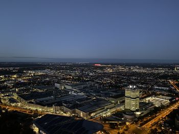 High angle view of illuminated city buildings against clear sky