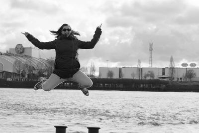 Full length of woman jumping in water