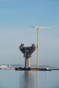 Cranes at construction site against sky