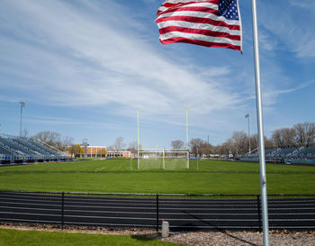 Flag on football field against blue sky