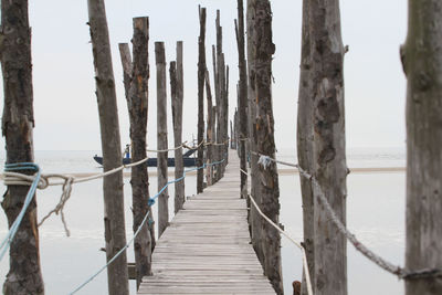 Wooden pier on sea against sky