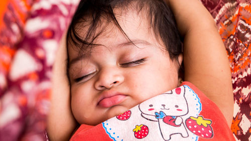 Close-up of cute baby girl sleeping at home