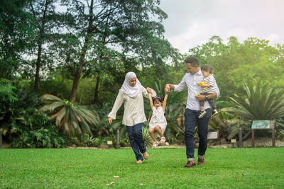 Happy family playing in public park