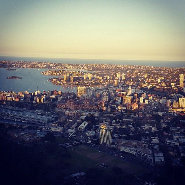 cityscape, city, architecture, building exterior, built structure, sea, high angle view, crowded, water, illuminated, aerial view, clear sky, residential district, city life, copy space, river, sky, residential building, residential structure, capital cities