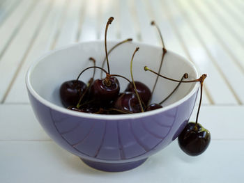 Fresh cherries in the bowl on the white table