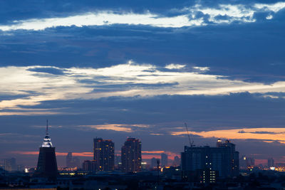 Modern buildings in city against cloudy sky