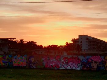 Graffiti on field against sky during sunset