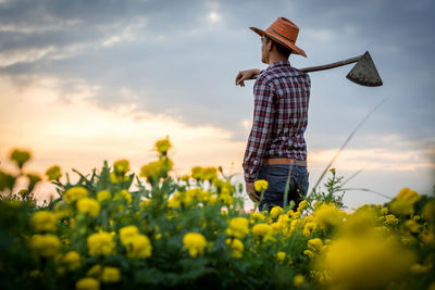 Low angle view of person standing on field against sky