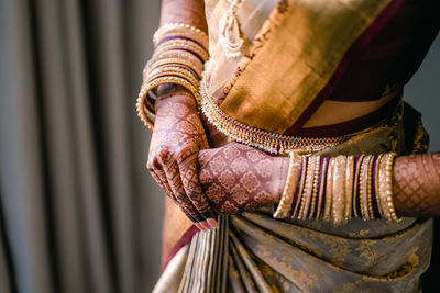 Midsection of woman standing against curtain