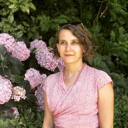 Beautiful woman standing against pink flowering plant