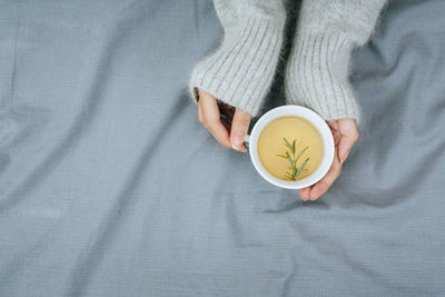 High angle view of woman with coffee on bed