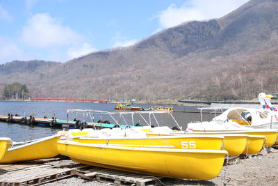 Boats in sea with mountain range in background