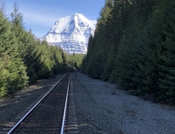 View of railroad track by mountain against sky