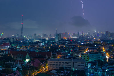 Illuminated cityscape against sky at night