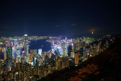 Illuminated cityscape against sky at night