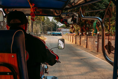 Rear view of man riding bicycle on road