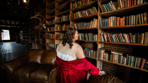 Portrait of beautiful woman standing in library