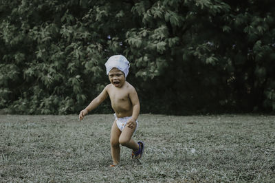 Shirtless boy walking on land