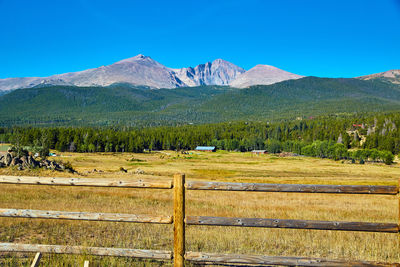 Scenic view of field and mountains against blue sky