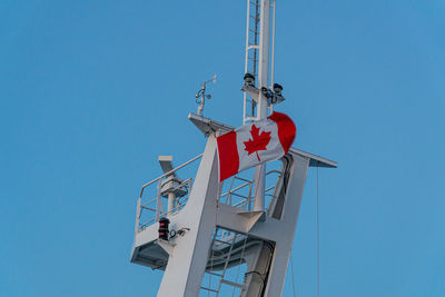 Low angle view of communications tower against blue sky