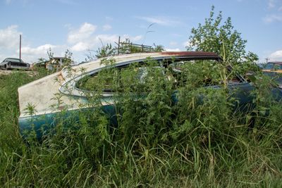 Abandoned car against sky