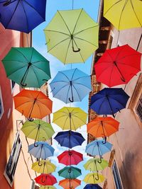 Low angle view of umbrellas hanging against sky