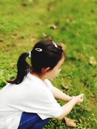 Side view of girl playing on grassy field