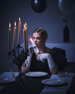 Portrait of young woman sitting on table