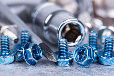 Close-up of screws with tools on table