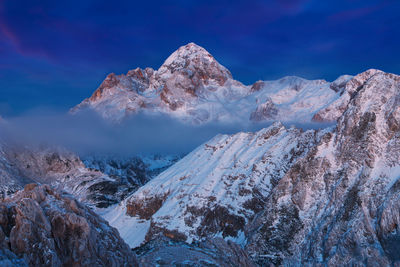 Scenic view of snowcapped mountains against blue sky