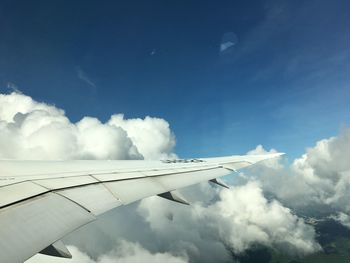 Airplane wing against cloudy sky