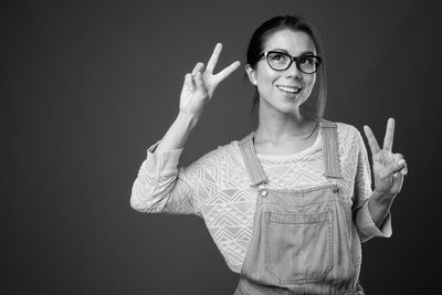 Smiling woman standing against black background