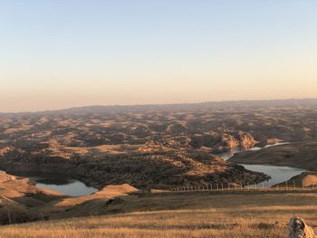 Scenic view of landscape against clear sky during sunset