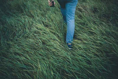 Low section of woman walking on grass