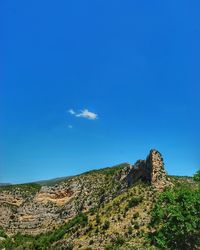 Low angle view of landscape against blue sky