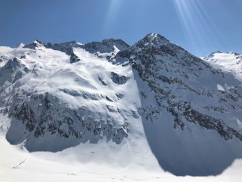 Scenic view of snow covered mountains against sky