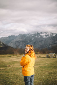 Man standing on field against mountains