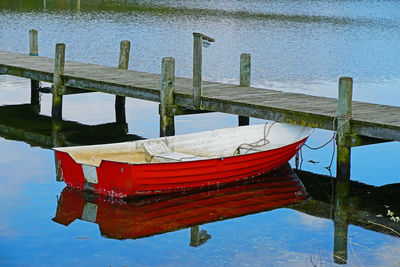 Boat moored in lake against sky