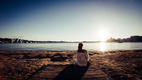 Rear view of woman looking at sea against sky