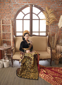 Portrait of woman sitting on sofa at home