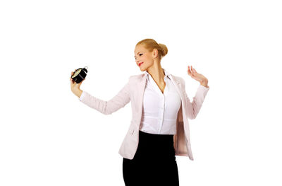 Young woman photographing against white background