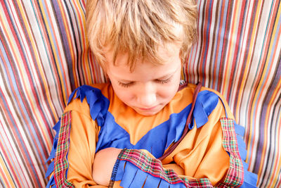 Boy looking away while standing on bed