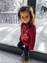 Portrait of smiling girl standing in snow