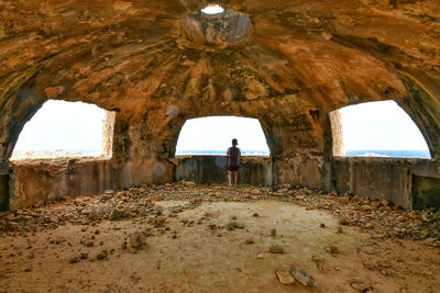 Rear view of people standing in tunnel