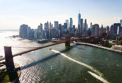 Aerial view of brooklyn bridge over river in city against sky