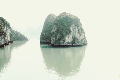 Scenic view of rocks in sea against clear sky