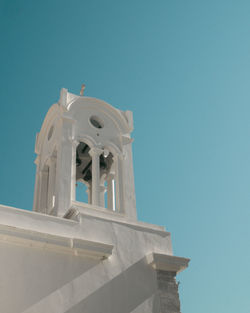 Low angle view of bell tower against clear blue sky