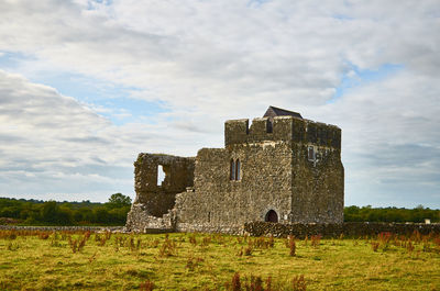 Old building on field against sky