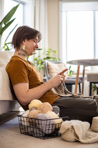 Side view of young woman using laptop at home