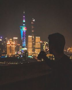 Illuminated buildings in city against sky at night